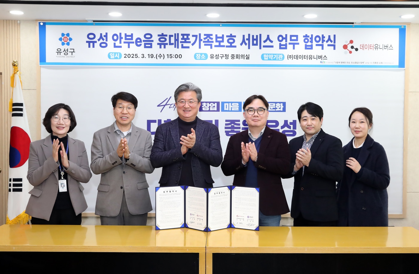 정용래 유성구청장(좌측에서 세 번째)과 강원석 데이터유니버스 대표이사(우측에서 세 번째)가 ‘유성 안부e음 휴대폰가족보호 서비스’ 업무협약을 체결하고 관계자들과 기념 촬영을 하고 있다. / 사진=유성구청 제공