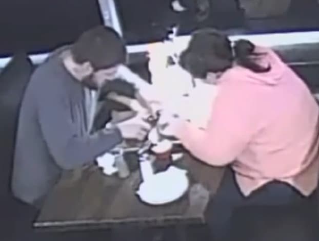 미국 테네시주 식당에서 식사중인 한 커플. 여성이 머리카락을 뽑고 남성이 팔을 뻗어 받은 후 음식에 넣는 영상 캡처(사진 출처 wdbj7.com)