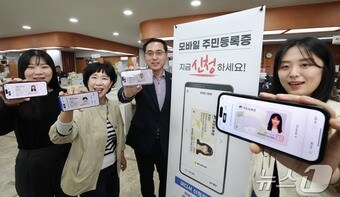 오는 28일 모바일 주민등록증 전면 시행을 앞두고 박희조 대전 동구청장이 26일 용운동 행정복지센터를 방문해 직접 모바일 주민등록증을 발급받고 직원들과 기념사진을 찍고 있다.(대전 동구 제공.재판매 및 DB금지)/뉴스1 
