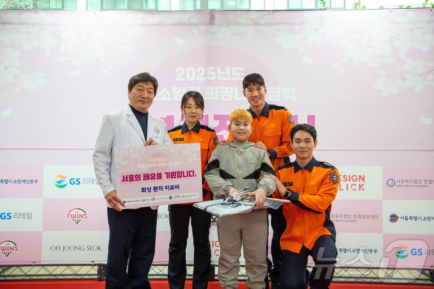 이른바 '몸짱소방관' 3인이 한림화상재단에서 화상환자에게 화상치료비를 전달하고 있다.(서울시 제공)