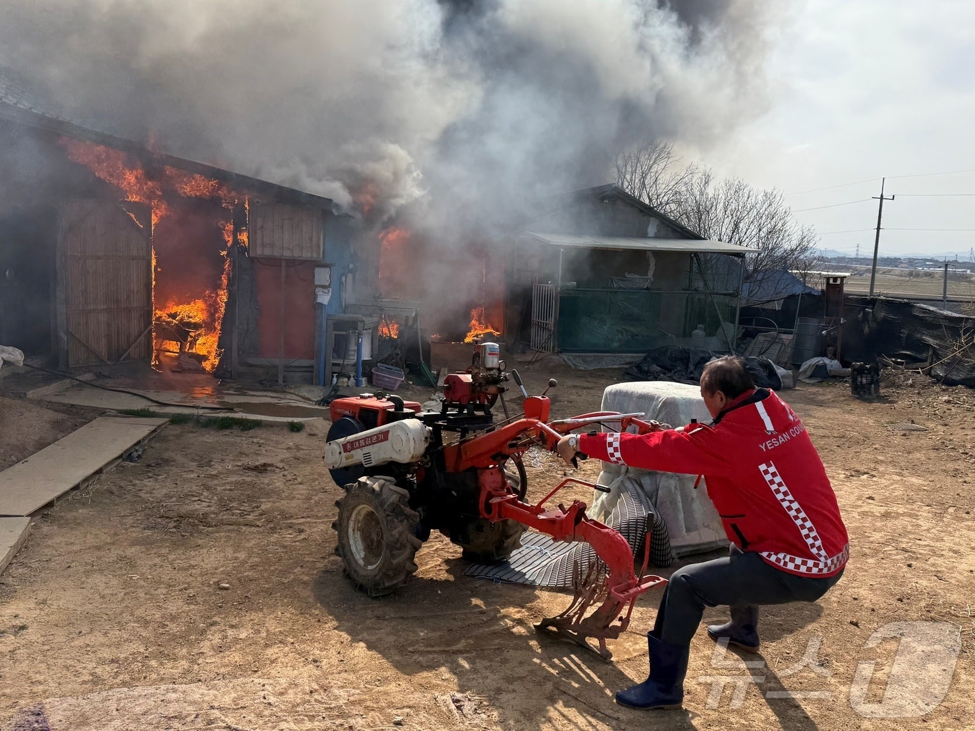 장순관 예산군의회 의장이 화재 현장에서 경운기 등을 안전한 곳으로 옮기고 있다. (예산군의회 제공. 재판매 및 DB금지)/뉴스1