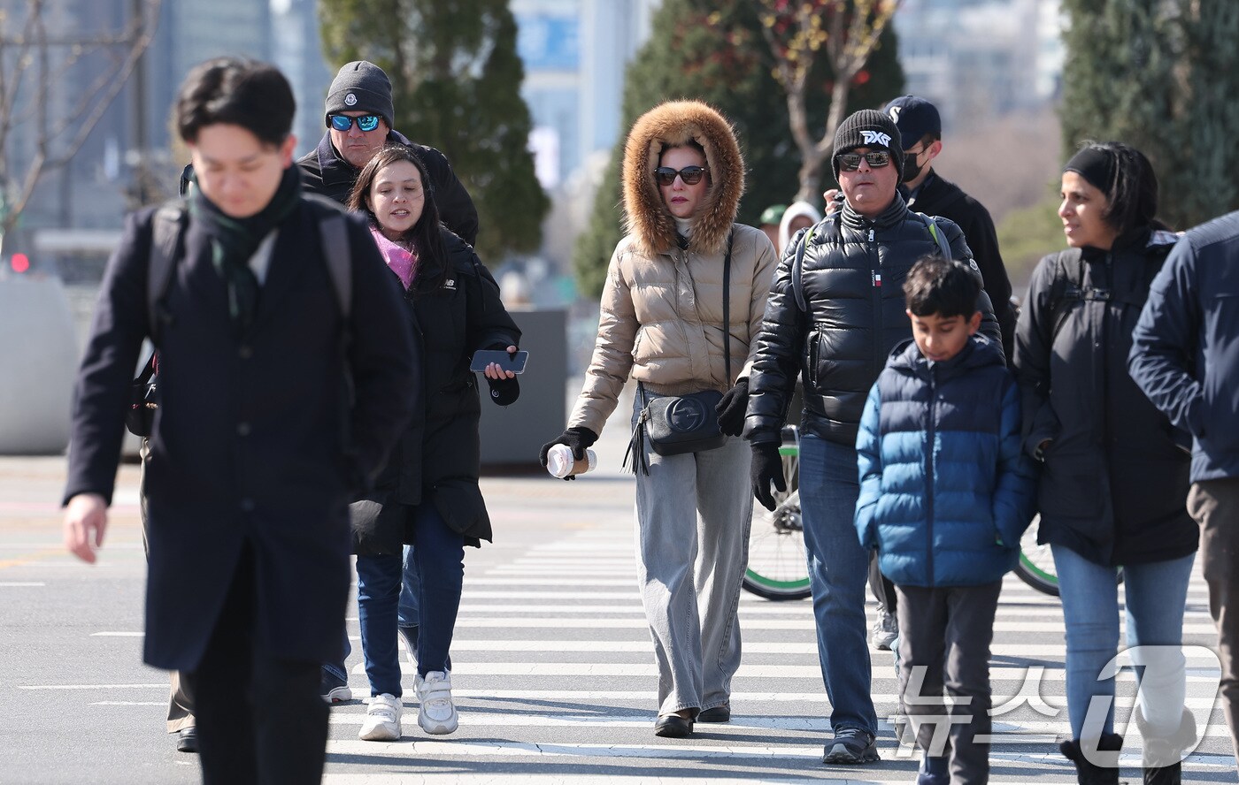 전국 대부분 지역에 강한 바람이 불고 최저 영하 1도까지 내려가는 등 꽃샘추위가 이어진 30일 서울 종로구 광화문광장에서 외국인 관광객들이 발걸음을 옮기고 있다. 2025.3.30/뉴스1 ⓒ News1 김성진 기자