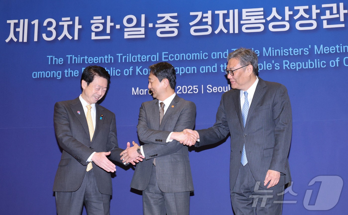 안덕근 산업통상자원부 장관(가운데)이 30일 오전 서울 중구 대한상공회의소에서 열린 제13차 한·일·중 경제통상장관회의에서 무토 요지 일본 경제산업성 대신(왼쪽), 왕 원타오 중국 상무부 부장과 기념 촬영을 하기 위해 손을 잡고 있다. 2025.3.30/뉴스1 ⓒ News1 신웅수 기자