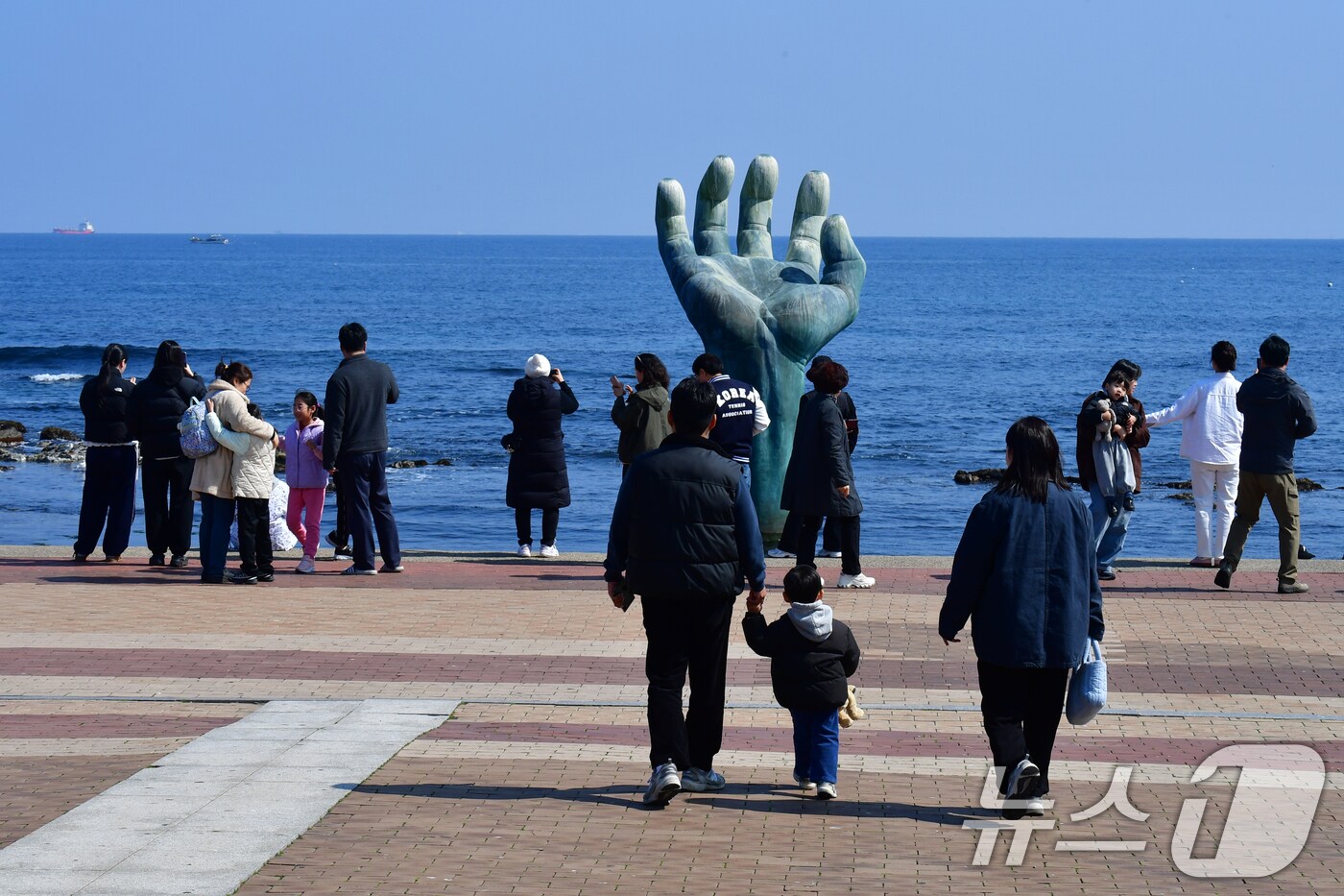 9일 경북 포항시 남구 호미곶 해맞이 광장 앞 바다에서 관광객들이 상생의 손을 배경으로 기념 촬영을 하고 있다. 2025.3.9/뉴스1 ⓒ News1 최창호 기자