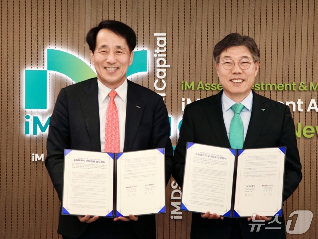 황병우 iM뱅크 은행장(오른쪽)과 장영진 한국무역보험공사 사장이 중소·중견 수출입기업을 위한 수출패키지 우대금융 협약을 체결한 뒤 협약서를 펼쳐 보이고 있다.(iM뱅크 제공. 재판매 및 DB 금지)