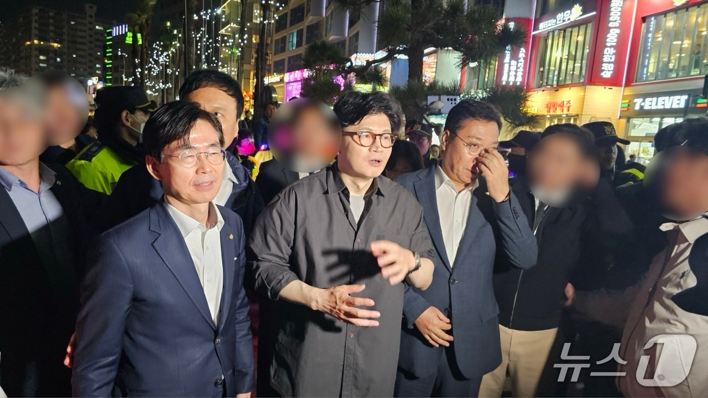 한동훈 전 국민의힘 대표(가운데)가 11일 조경태 의원(왼쪽), 정연욱 의원과 부산 수영구 광안리해수욕장을 방문해 도보유세를 하고 있다.2025.4.11/뉴스1 ⓒ News1 장광일 기자