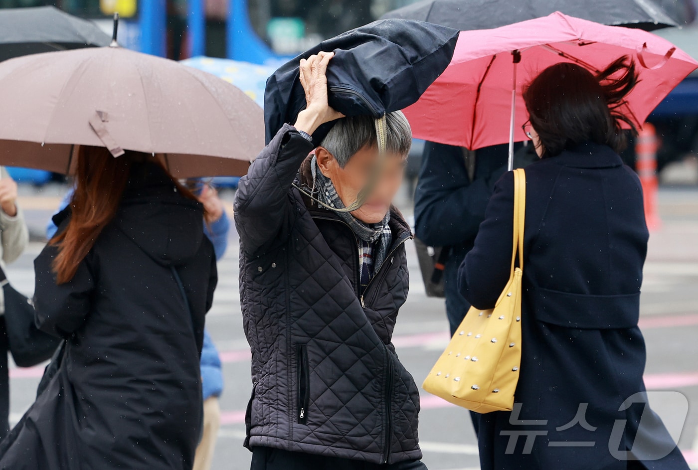 14일 오전 서울 종로구 광화문 네거리에서 한 시민이 가방으로 머리를 가린 채 발걸음을 옮기고 있다.  2025.4.14/뉴스1 ⓒ News1 김진환 기자