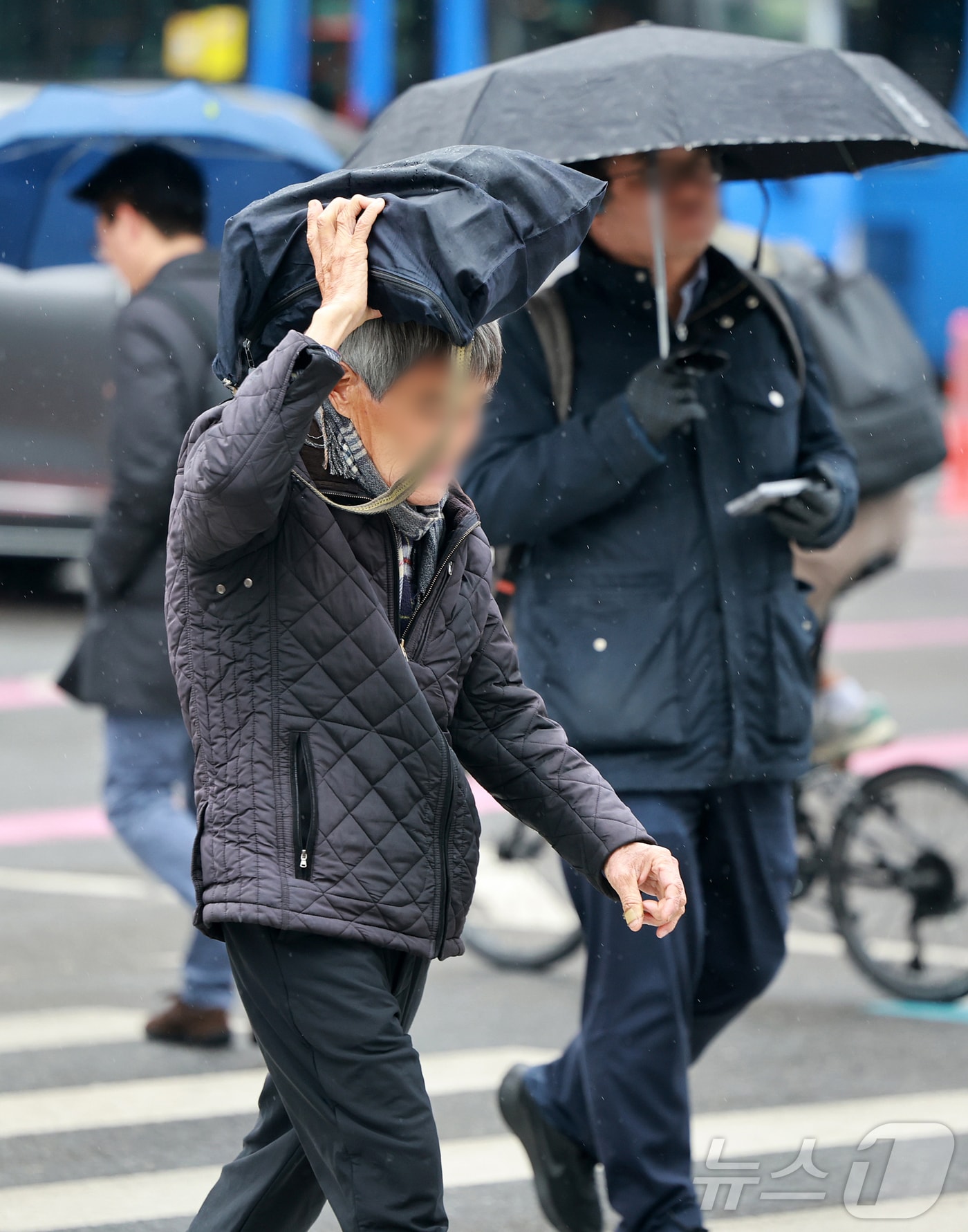 14일 오전 서울 종로구 광화문 네거리에서 한 시민이 가방으로 머리를 가린 채 발걸음을 옮기고 있다. 기상청은 이날 전국 대부분 지역에 비 또는 눈이 내리겠고, 돌풍과 함께 천둥·번개가 치고 일부 지역에는 싸락우박이 떨어질 수 있다고 밝혔다. 2025.4.14/뉴스1 ⓒ News1 김진환 기자