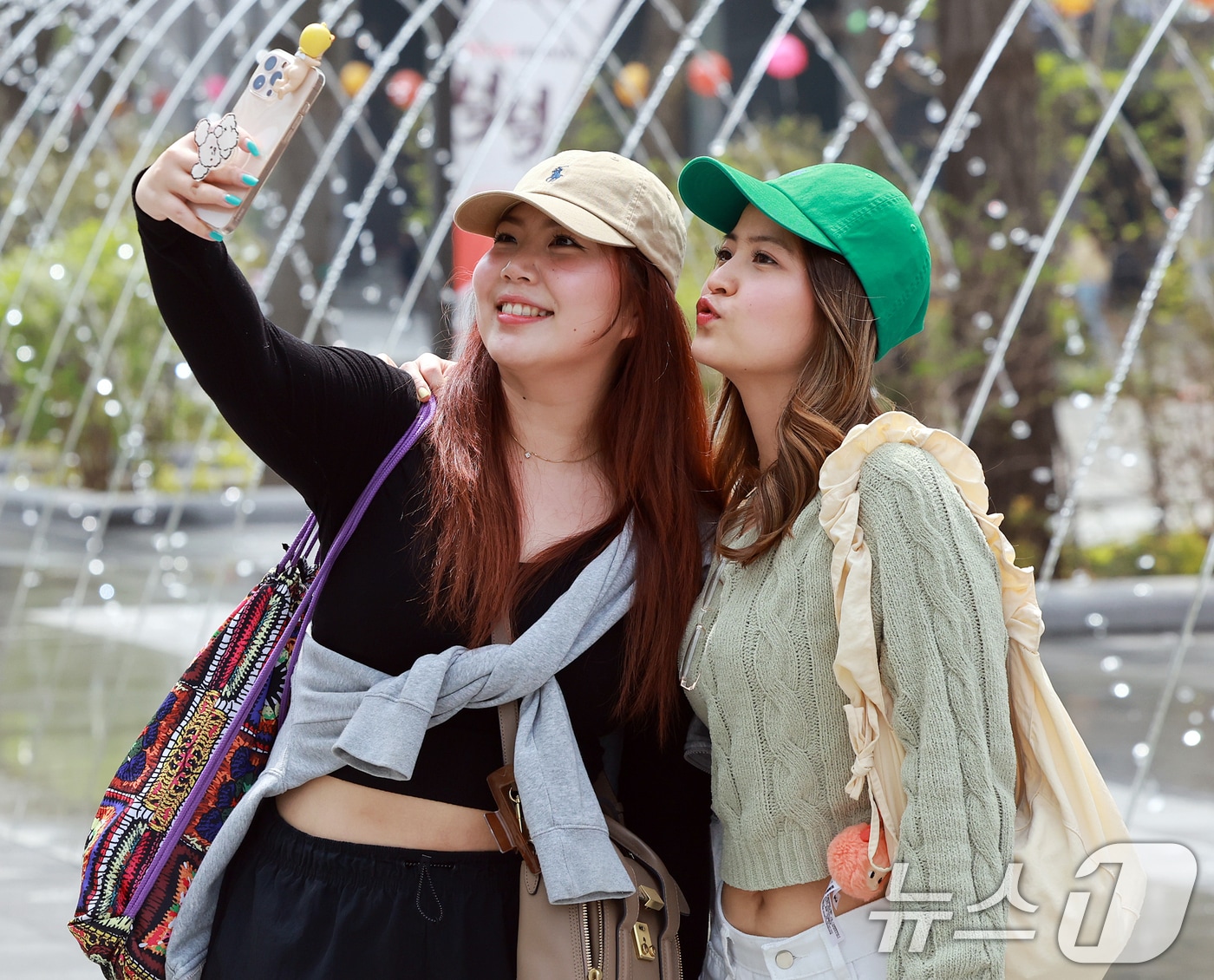 서울 종로구 광화문광장을 찾은 외국인 관광객들이 분수 터널을 배경으로 추억을 남기고 있다.2025.4.18/뉴스1 ⓒ News1 김진환 기자