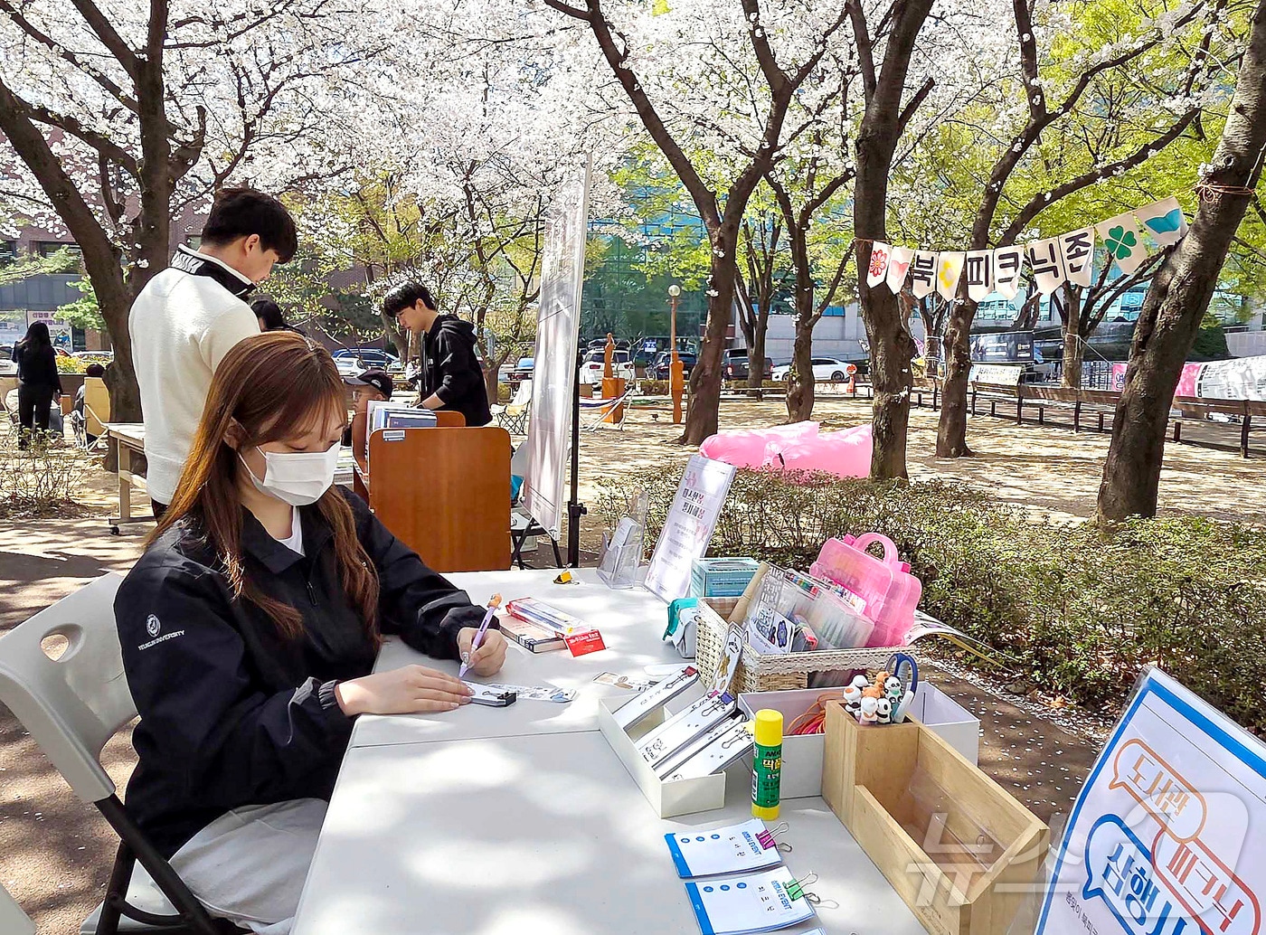 영진전문대 학생들이 도서관 앞 벚꽃 숲길에서 북피크닉을 즐기고 있다. (영진전문대 제공)