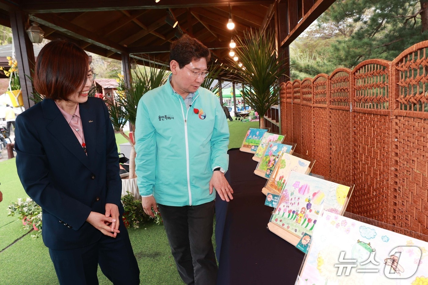 이상일 시장이 19일 농촌테마파크에서 열린 '봄에 취해, 봄' 행사에서 개최된 어린이 사생대회 출품 그림을 보고 있다.(용인시 제공)