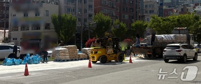 21일 오후 부산 중구 부산터널삼거리를 달리던 25톤 화물트럭에서 밀가루 포대가 쏟아져 경찰이 현장을 통제하고 있다. (부산경찰청 제공. 재판매 및 DB 금지)