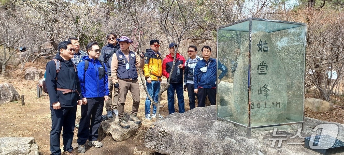 숲길등산지도사가 등산객에게 고당봉 표지석에 대해 설명하고 있다.(부산시청 제공. 재판매 및 DB 금지)