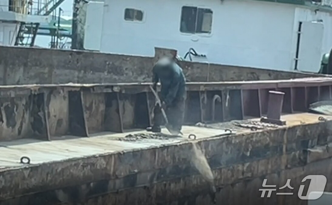 21일 전남 목포시 남항부두에서 한 선박 관계자가 수리 작업 중 바다에 폐기물을 무단 투기하고 있는 모습.(목포해경 제공. 재판매 및 DB 금지)