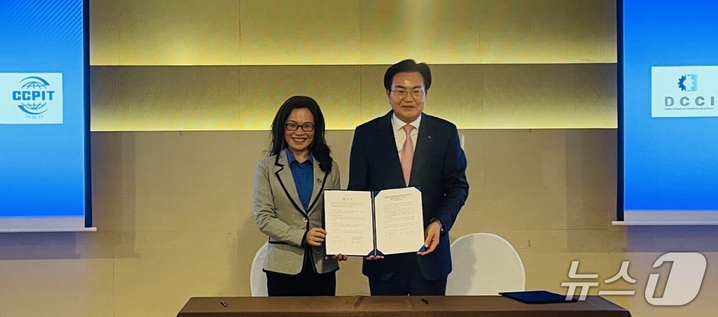 이상길 대구상공회의소 상근부회장(오른쪽)과 황리 중국 쓰촨성무역촉진위원회 회장이 상호 협력 강화를 위한 업무협약을 체결한 뒤 협약서를 펼쳐 보이고 있다.(대구상의 제공. 재판매 및 DB 금지)