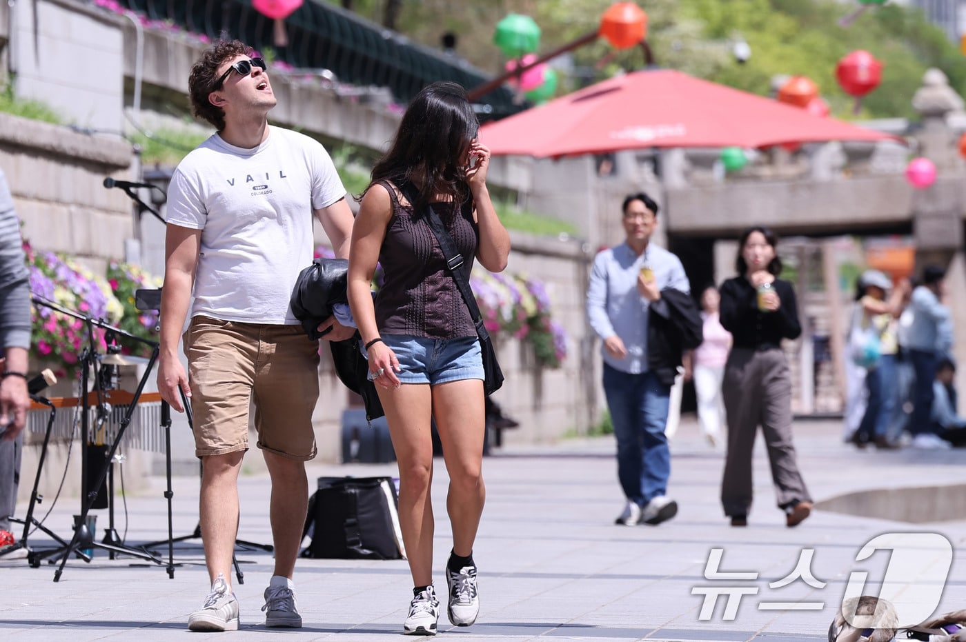 초여름에 가까운 날씨를 보인 30일 오후 서울 청계천을 찾은 외국인 관광객이 겉옷을 든 채 이동하고 있다. 2025.4.30/뉴스1 ⓒ News1 박지혜 기자