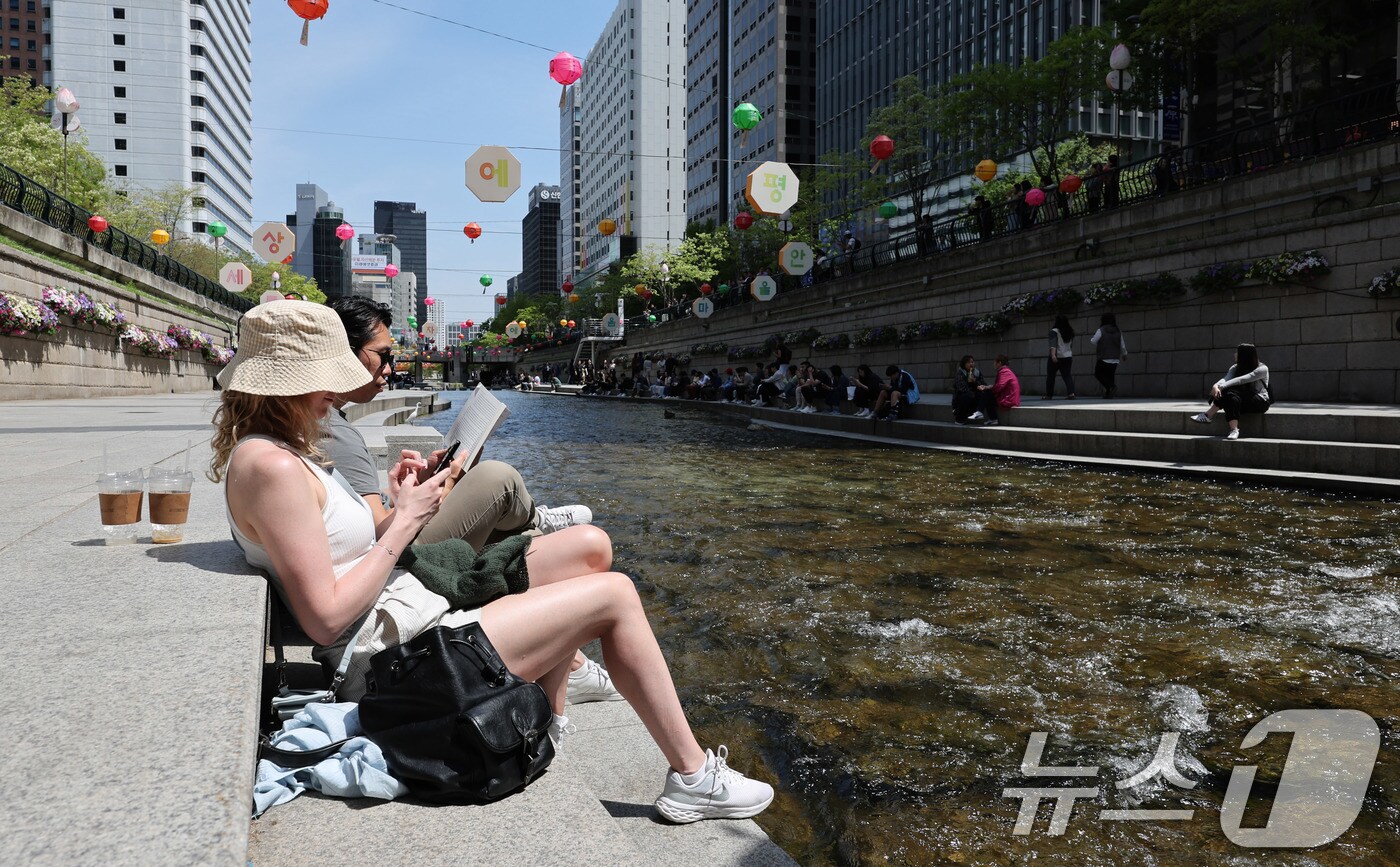 초여름에 가까운 날씨를 보인 30일 오후 서울 청계천을 찾은 외국인 관광객이 가벼운 옷차림으로 휴식을 취하고 있다. 2025.4.30/뉴스1 ⓒ News1 박지혜 기자