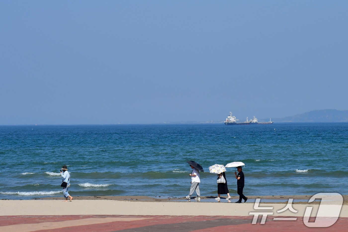 30일 오후 경북 포항시의 낮 최고 기온이 29.3도까지 올라가며 초여름 날씨를 보인 가운데 영일대해수욕장 백사장에서 양산을 쓴 관광객들이 걸어가고 있다. 2025.4.30/뉴스1 ⓒ News1 최창호 기자