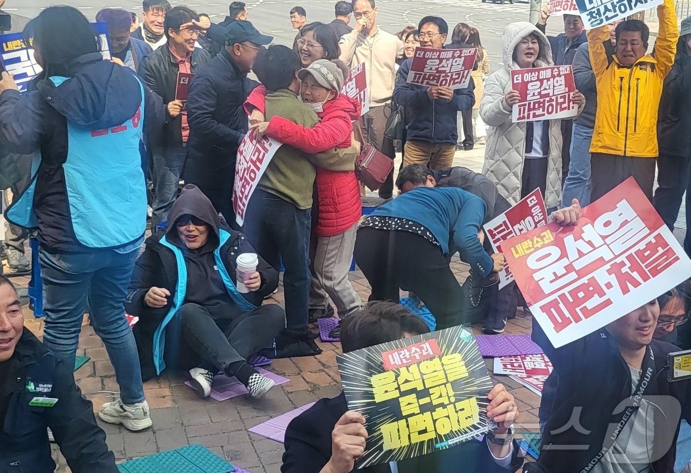 윤석열 대통령 탄핵심판 선고일인 4일 강원 원주의료원 사거리에서 헌재의 선고를 생중계로 지켜본 시민들이 부둥켜안고 환호하고 있다. 2025.4.4./뉴스1 ⓒ News1 신관호 기자
