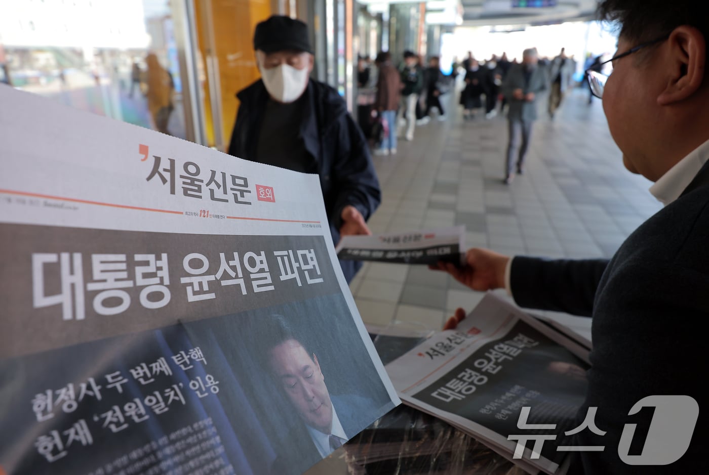 윤석열 대통령에 대한 파면이 결정된 4일 오후 서울 용산구 한강대로 서울역에서 서울신문 호외를 시민들에게 나눠주고 있다. 헌법재판소는 이날 오전 11시 22분 재판관 전원 일치 의견으로 파면 결정을 내렸다. ⓒ News1 박정호 기자
