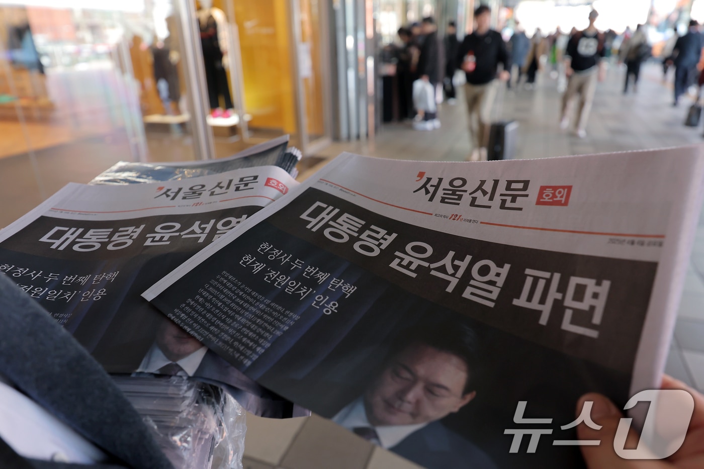 윤석열 대통령에 대한 파면이 결정된 4일 오후 서울 용산구 한강대로 서울역에서 서울신문 호외를 시민들에게 나눠주고 있다. 헌법재판소는 이날 오전 11시 22분 재판관 전원 일치 의견으로 파면 결정을 내렸다. 2025.4.4/뉴스1 ⓒ News1 박정호 기자
