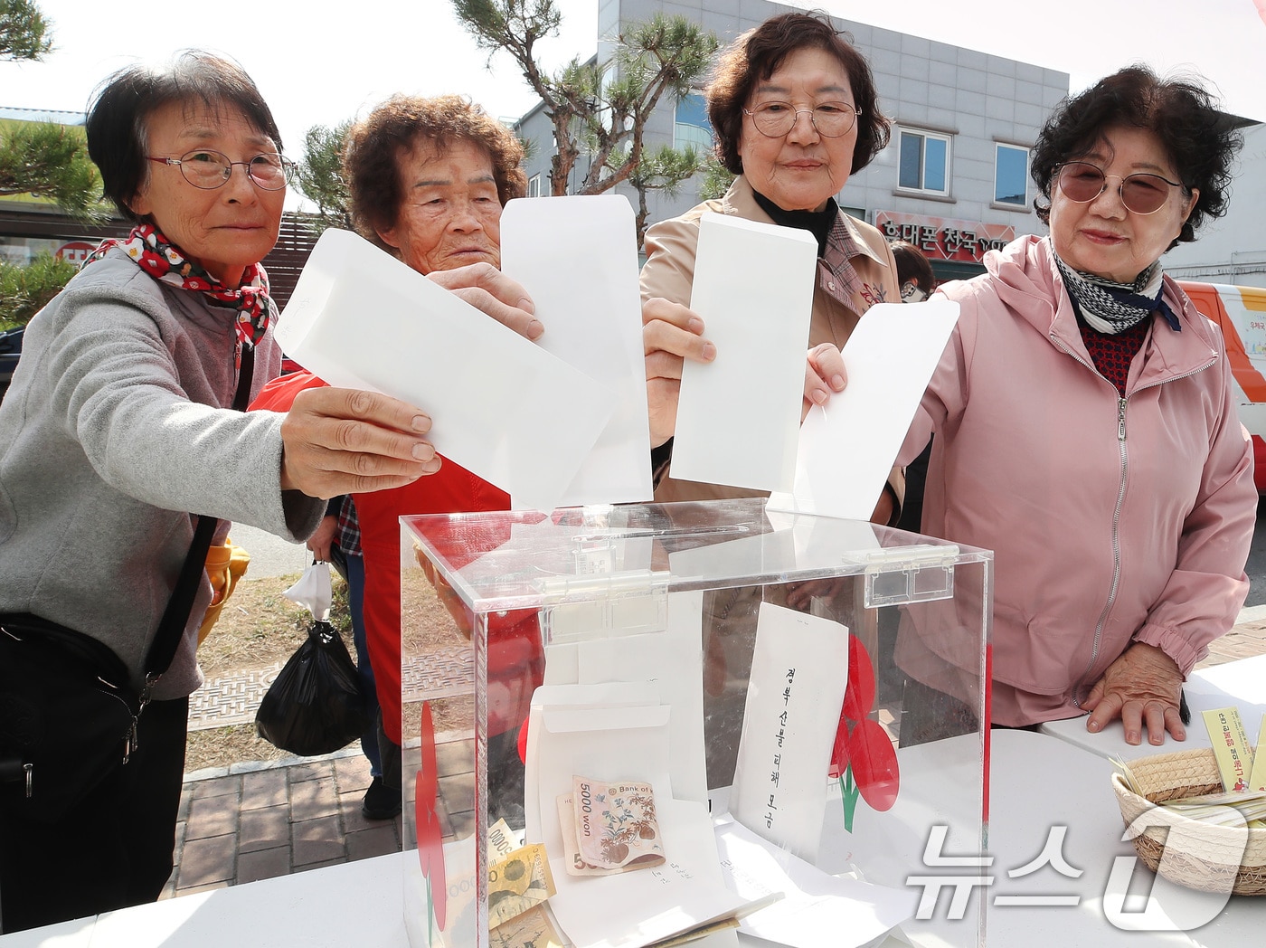 지난 8일 대구 군위군 군위전통시장 앞에서 열린 경북 산불피해 지역 돕기 거리모금에 참여한 주민들이 성금을 모금함에 넣고  있다. 2025.4.8/뉴스1 ⓒ News1 공정식 기자