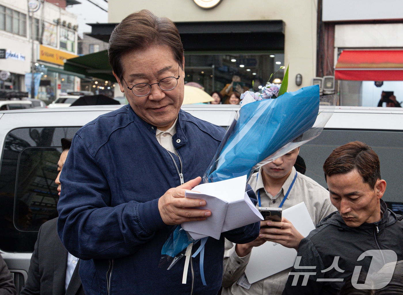 이재명 더불어민주당 대통령 후보가 1일 오후 경기도 연천군 전곡시외터미널 인근에서 선물받은 꽃다발과 편지를 살펴보고 있다. 2025.5.1/뉴스1 ⓒ News1 이재명 기자