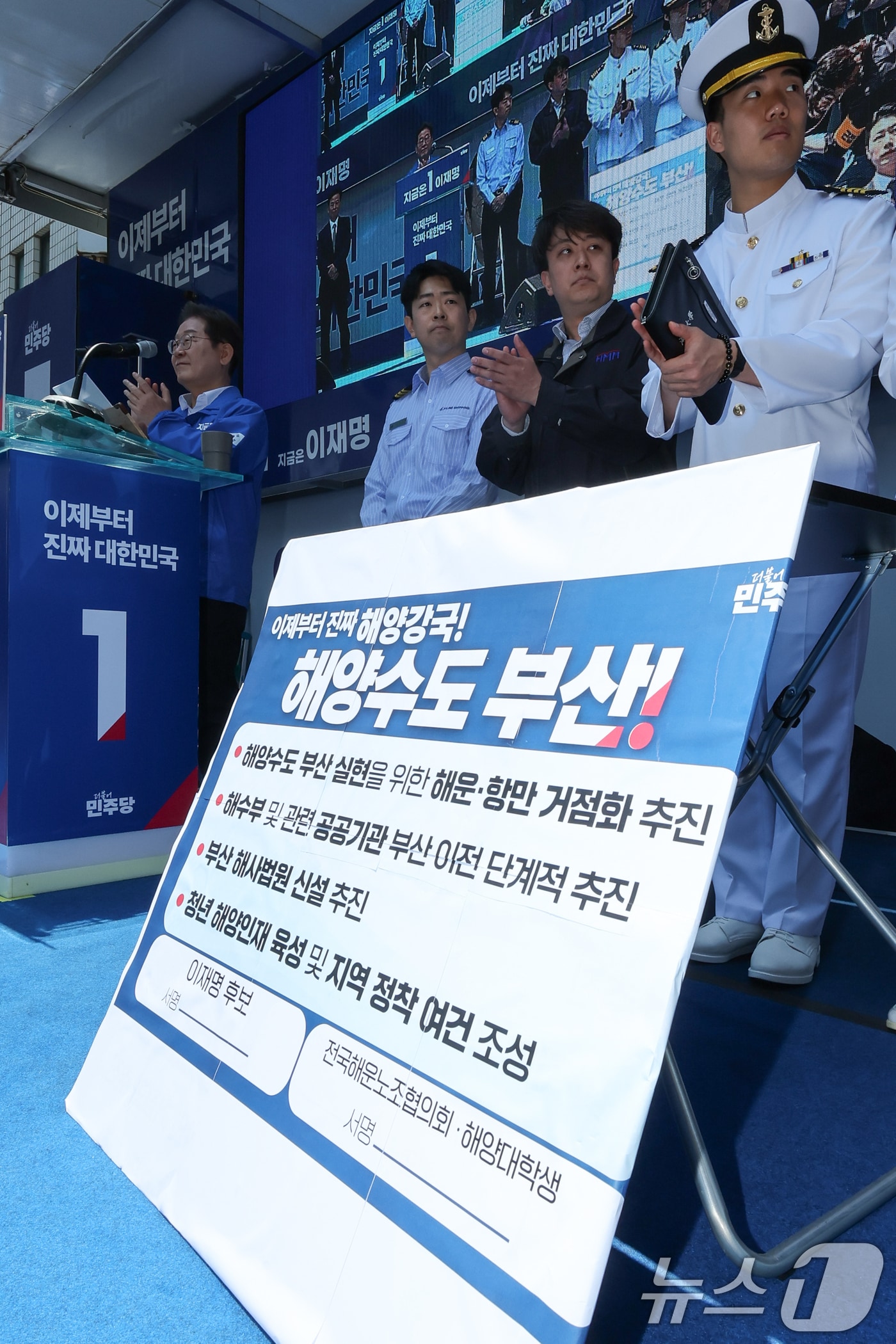 이재명 더불어민주당 대통령 후보가 민주당 험지로 꼽히는 부산·경남(PK) 지역 유세에 나선 14일 부산 부산진구 서면에서 권기흥 에이치라인해운해상직원노조 위원장과 해양수도 부산 협약서에 서명하기 전 손뼉치고 있다. 2025.5.14/뉴스1 ⓒ News1 안은나 기자