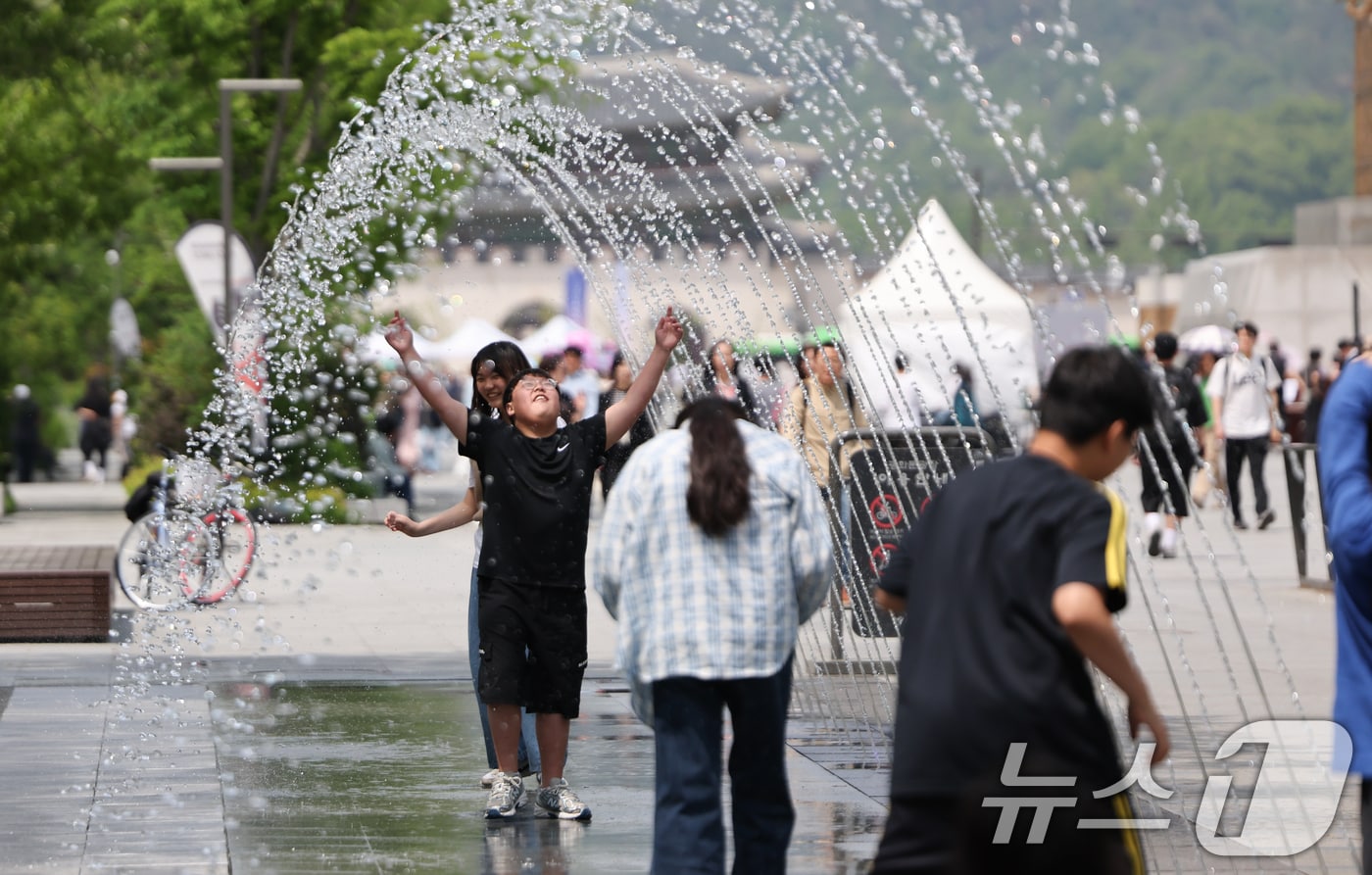 서울 낮 최고 기온 26도 등 초여름 날씨을 보인 14일 서울 광화문광장 분수터널에서 시민들이 더위를 식히고 있다. 2025.5.14/뉴스1 ⓒ News1 허경 기자