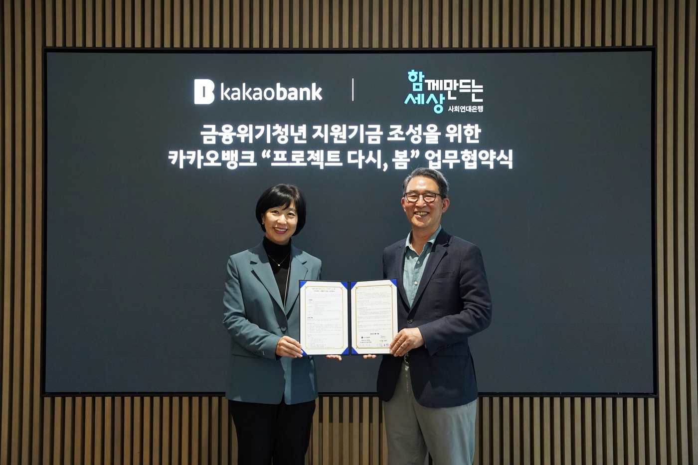 박정윤 카카오뱅크 컴플라이언스실장(왼쪽)과 김용덕 함께만드는세상 이사장이 업무협약을 체결하는 모습.(카카오뱅크 제공)