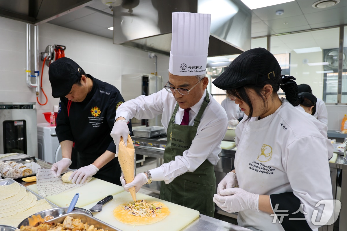 이희학 총장(가운데)이 그릴드치킨롤 샌드위치를 만들고 있다.(목원대 제공.재판매 및 DB금지)/뉴스1