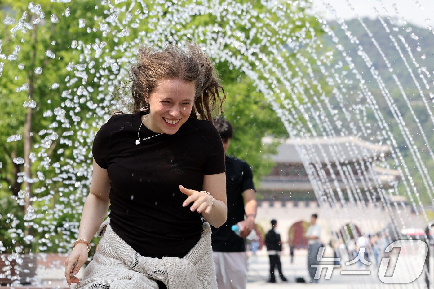서울 종로구 광화문광장 분수터널에서 외국인 관광객들이 더위를 식히고 있다. 2025.5.20/뉴스1 ⓒ News1 이동해 기자