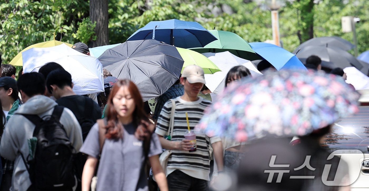 전국적으로 초여름 날씨를 보인 22일 학생들이 우산과 양산으로 햇빛을 가린 채 노천극장 입장을 기다리고 있다. 2025.5.22/뉴스1 ⓒ News1 김성진 기자