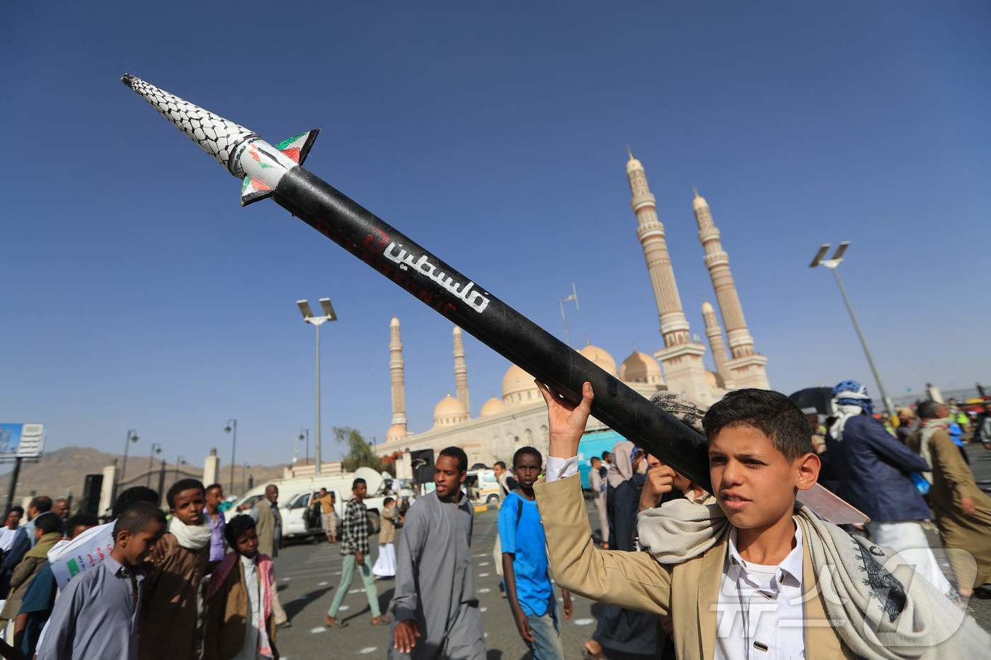 예멘의 한 소년이 가짜 미사일을 들고 팔레스타인과 가자지구와의 연대를 표명하는 시위에 참여하고 있다. 2025.05.16.ⓒ AFP=뉴스1
