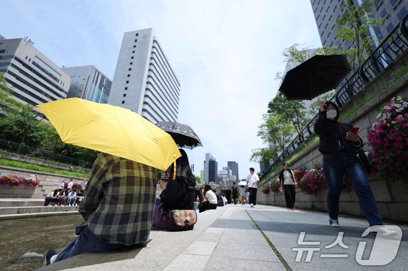 서울 청계광장에서 겉옷을 벗거나 양산을 쓴 시민들이 올해 마지막 봄을 즐기고 있다. 2025.5.26/뉴스1 ⓒ News1 신웅수 기자