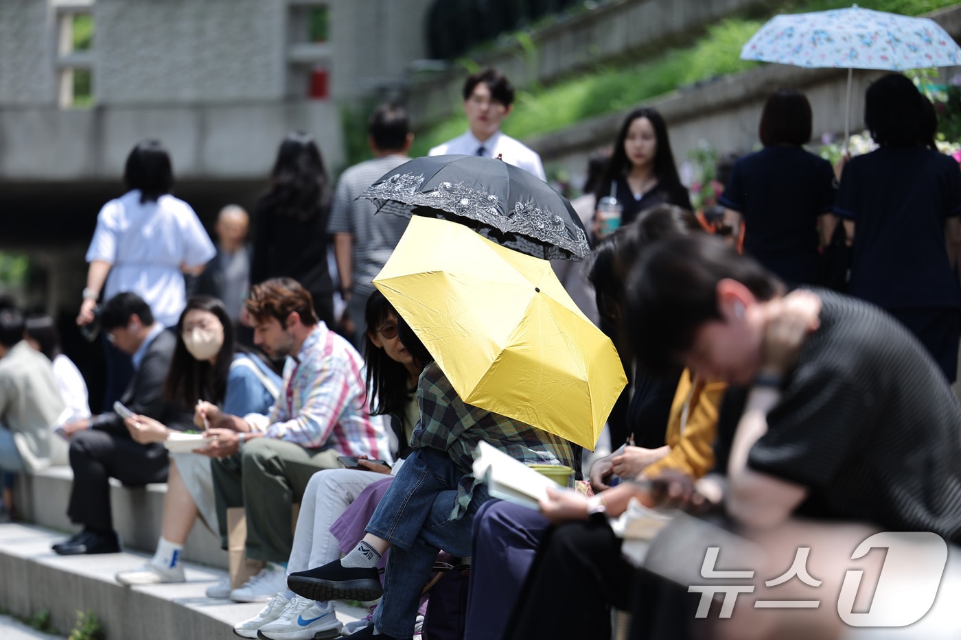 26일 오후 서울 청계광장에서 겉옷을 벗거나 양산을 쓴 시민들이 올해 마지막 봄을 즐기고 있다. 기상청은 내일과 모레 동쪽 지방을 중심으로 요란한 소나기가 지나가고 주 후반에는 30도 안팎의 더위가 나타날 것으로 예보했다. 2025.5.26/뉴스1 ⓒ News1 신웅수 기자