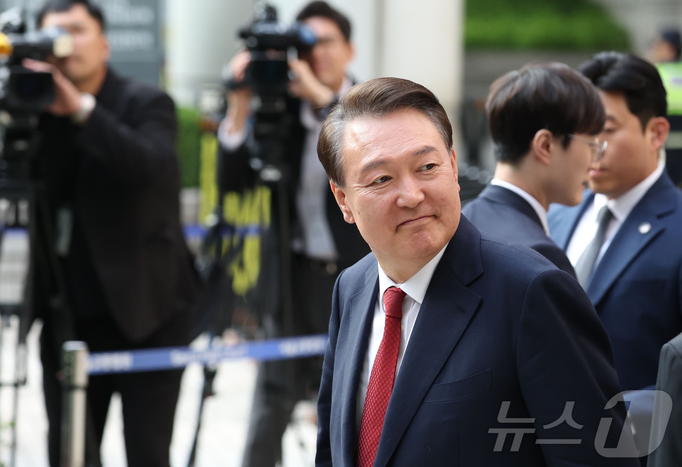 윤석열 전 대통령이 지난달 26일 오후 서울 서초구 중앙지방법원에서 열린 내란 우두머리 혐의, 직권남용 권리행사방해 혐의 사건 5차 공판을 마친 후 법원을 나서며 지지자들을 보고 있다. 2025.5.26/뉴 스1 2025.5.26/뉴스1 ⓒ News1 사진공동취재단