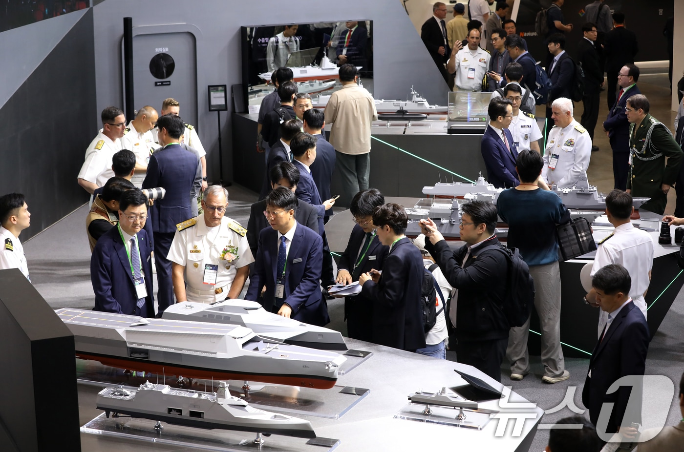 28일 부산 해운대구 벡스코 제1전시장에서 열린 '2025 국제해양방위산업전(MADEX)'에서 참가자들이 HD현대중공업 부스를 찾아 미래형 무인전력모함 등을 살펴보고 있다. 2025.5.28/뉴스1 ⓒ News1 윤일지 기자