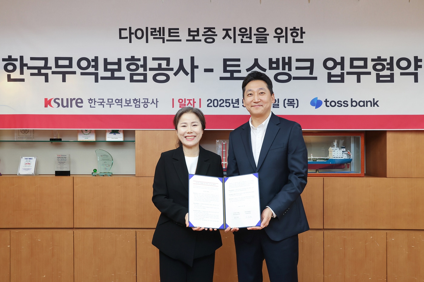 유승희 한국무역보험공사 디지털사업단장(왼쪽)과 박신건 토스뱅크 담보여신파트본부장이 광화문 한국무역보험공사 본사에서 업무협약 체결 후 기념 촬영을 하고 있다.(토스뱅크 제공)