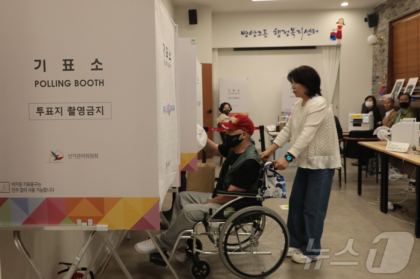 제21대 대통령선거 사전투표 이틀차인 30일 오전 울산 중구 병영2동 행정복지센터에서한 시민이 보조인의 도움을 받아 휠체어를 타고 기표소로 들어가고 있다. 2025.5.30/뉴스1 ⓒ News1 김세은 기자