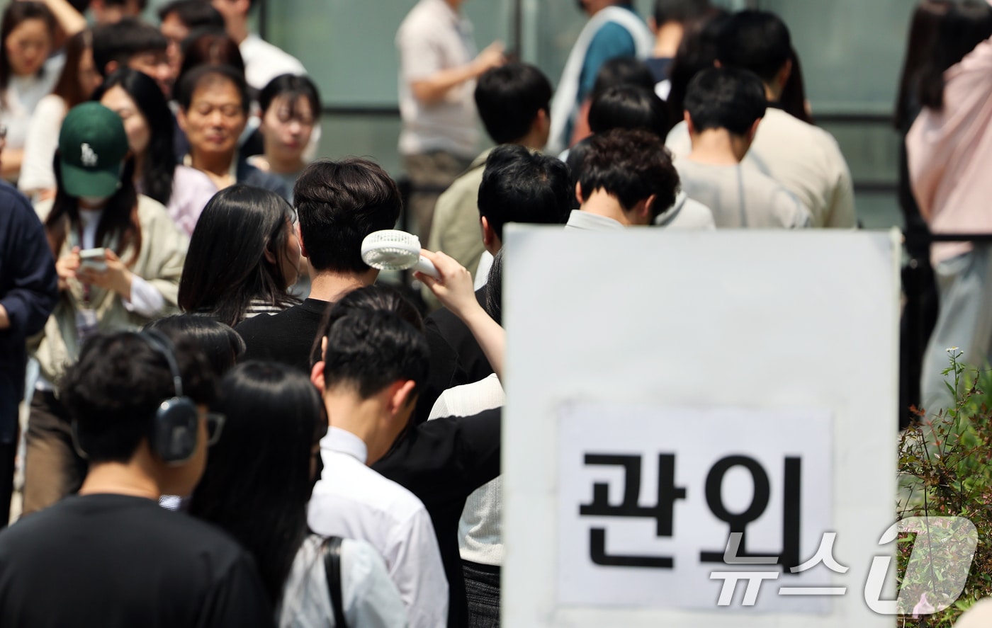 제21대 대통령 선거 사전 투표 둘째 날인 30일 오후 서울 강남구 역삼1동 주민센터에 마련된 사전투표소에서 점심시간을 이용해 투표소를 찾은 유권자들이 손선풍기로 더위를 피하며 길게 줄을 늘어서 있다. 2025.5.30/뉴스1 ⓒ News1 오대일 기자