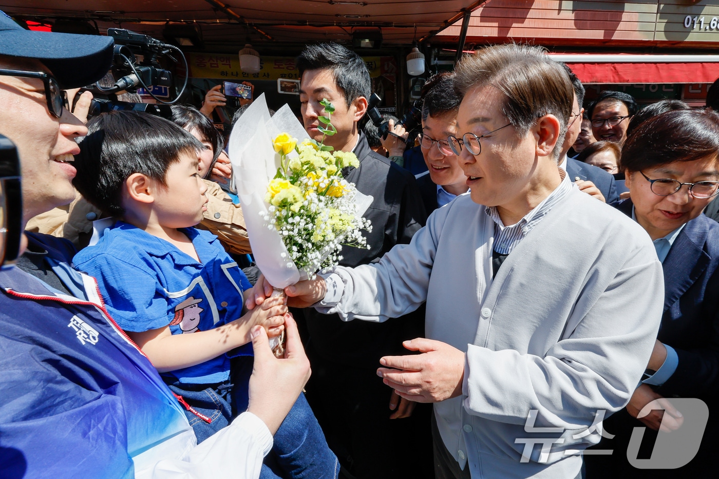 이재명 더불어민주당 대통령 후보가 2차 골목골목 경청투어 마지막 날인 7일 오전 전북 진안군 진무로를 찾아 어린이에게 꽃다발을 선물받고 있다. 2025.5.7/뉴스1 ⓒ News1 안은나 기자