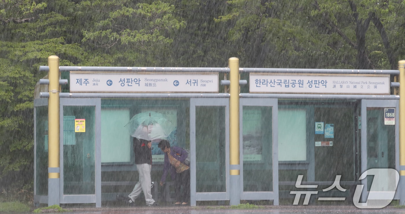 한라산국립공원 성판악 탐방로 버스 정류장에서 탑승객들이 비를 피하고 있다. 2025.5.9/뉴스1 ⓒ News1 오현지 기자
