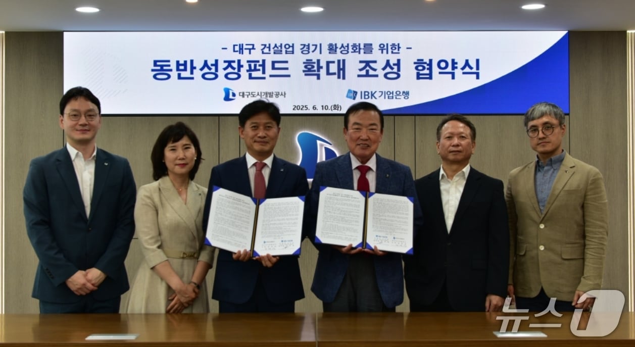 정명섭 대구도시개발공사 사장(오른쪽 세번째)과 이대홍 기업은행 대구경북동부지역본부장(왼쪽 세번째)이 대구 건설업 경기 활성화를 위한 '동반성장펀드 확대 조성' 협약을 체결한 후 협약서를 펼쳐 보이고 있다.(대구도시개발공사 제공. 재판매 및 DB 금지)