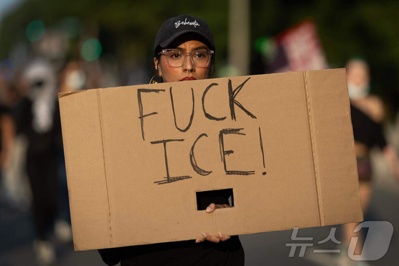2025년 6월 10일 일리노이주 시카고에서 이민자 권리를 옹호하는 시위자가 거리행진에 참여하며 '엿먹어라, ICE(이민세관단속국)'라고 적힌 팻말을 들고 있다. ⓒ AFP=뉴스1 ⓒ News1 신기림 기자 