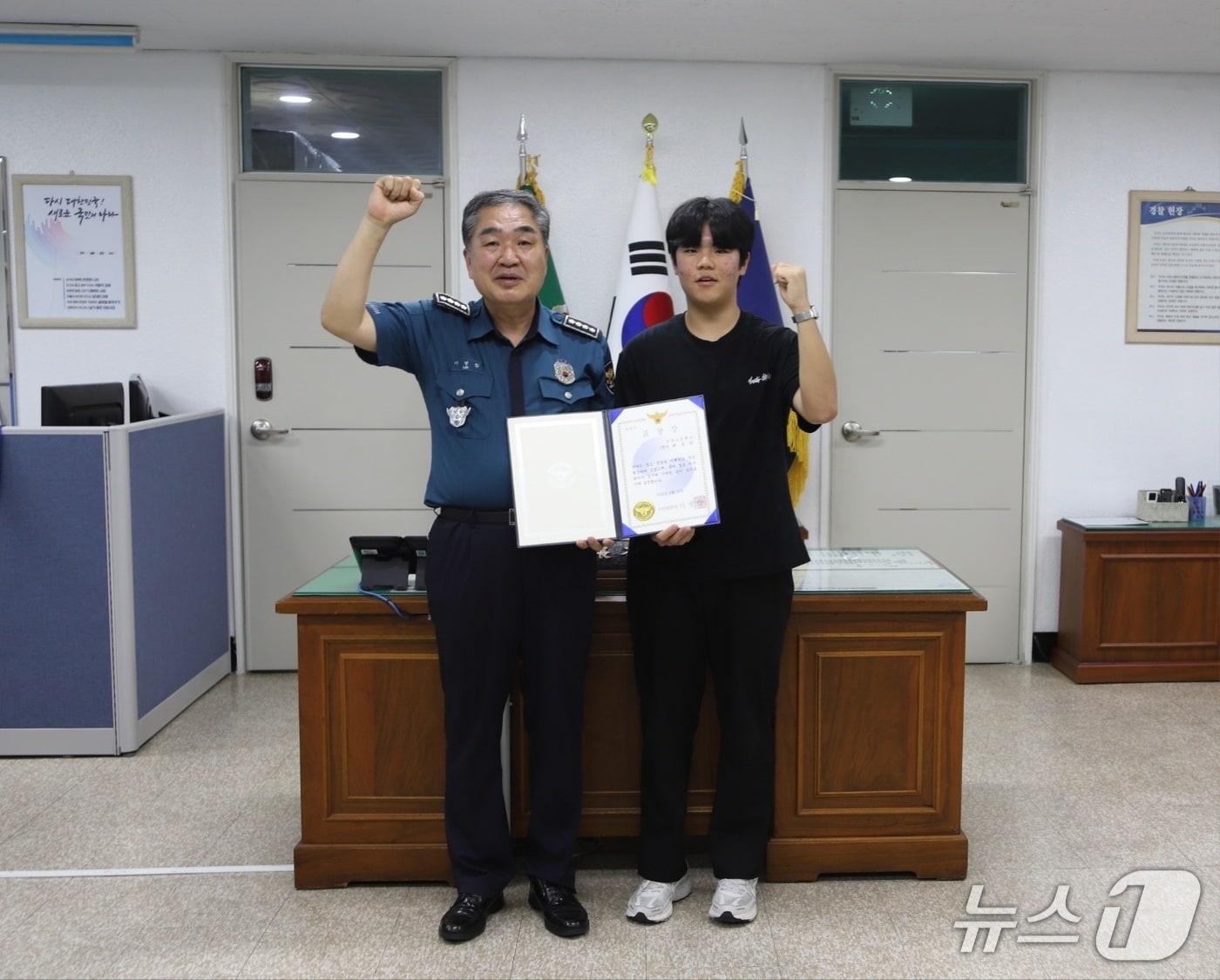 절도 피의자를 검거하는데 도움을 준 최성윤 군(왼쪽)이 표창장을 받고 경찰 관계자와 기념사진을 찍고 있다.(부산 연제경찰서 제공. 재판매 및 DB 금지)