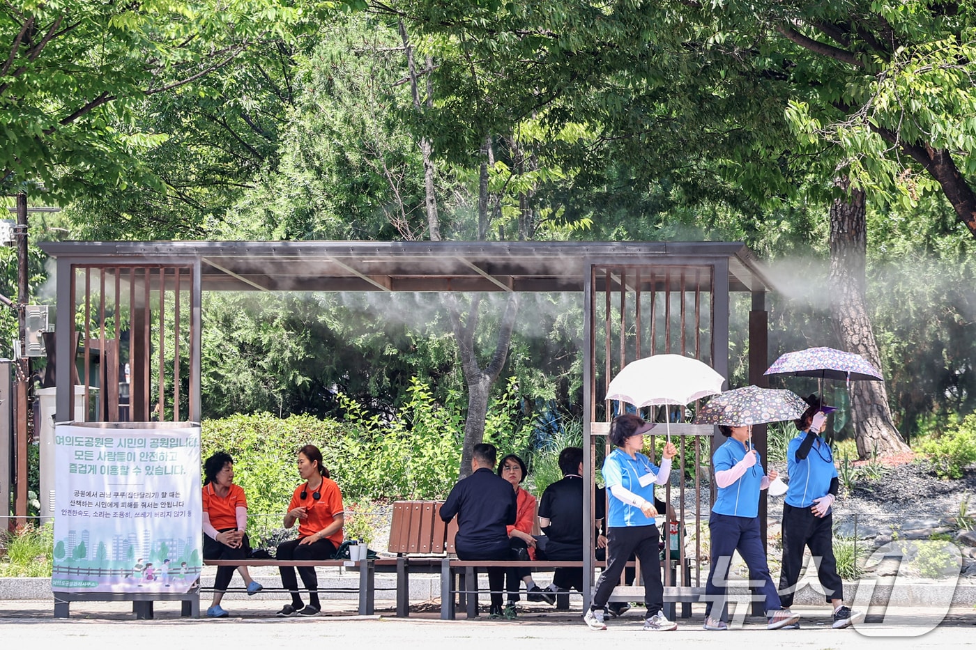 서울 지역 낮 최고기온이 31도까지 올라 초여름 더위가 찾아온 12일 서울 영등포구 여의도공원에서 시민들이 쿨링포그 아래에 앉아 무더위를 쫓고 있다. 2025.6.12/뉴스1 ⓒ News1 민경석 기자