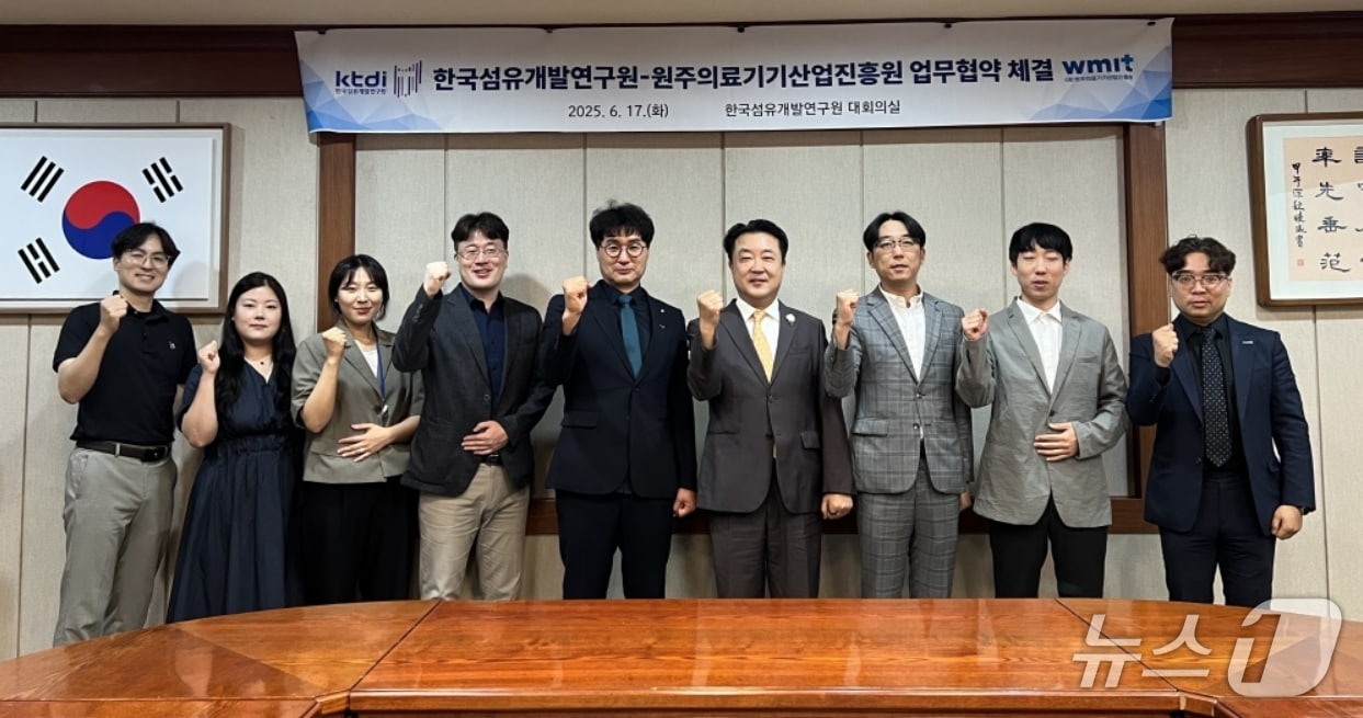 한국섬유개발연구원과 원주의료기기산업진흥원 직원들이 의료용 융합소재 공동 연구와 기술 발전 촉진을 위한 업무협약을 체결한 뒤 파이팅을 외치고 있다.(섬유개발연구원 제공. 재판매 및 DB 금지)