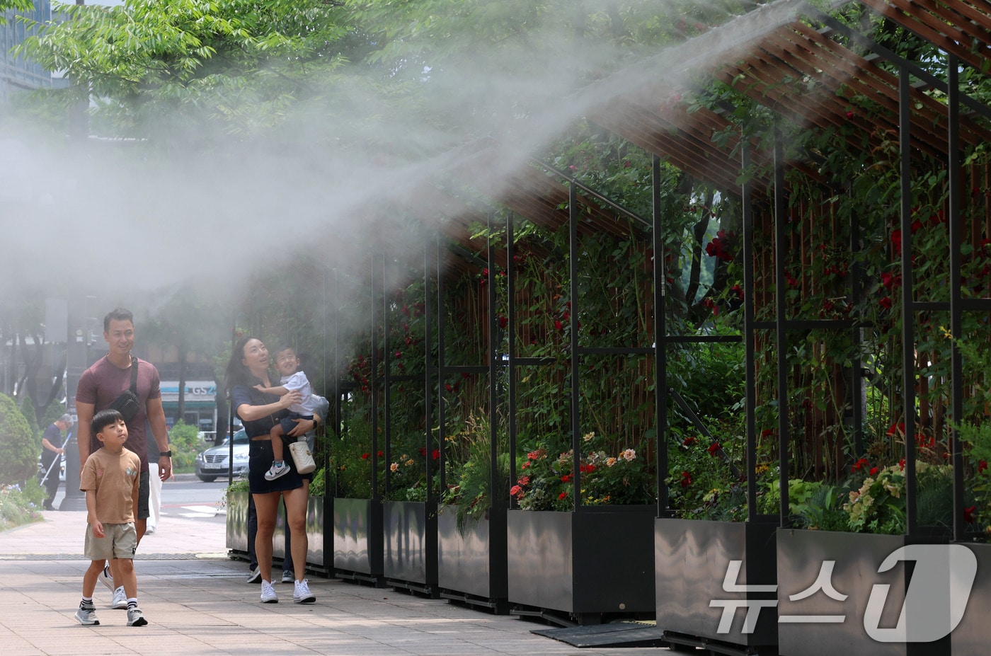 서울시청 앞 서울광장을 찾은 한 가족이 쿨링포그 앞을 지나며 더위를 식히고 있다. 2025.6.17/뉴스1 ⓒ News1 박세연 기자