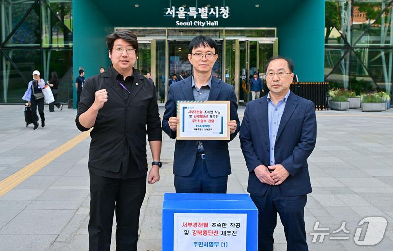 문성호 서울시의원과 서대문구 황원근 안전건설국장 및 최종구 도로과장이 서울시에 '서울 경전철 서부선의 조속한 착공과 강북횡단선 재추진'을 요청하는 주민 서명부를 전달하기에 앞서 기념 촬영을 하고 있다.(서대문구 제공)